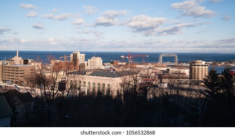 The city skyline rises up from the tree branches on a cold winter day in Duluth MN