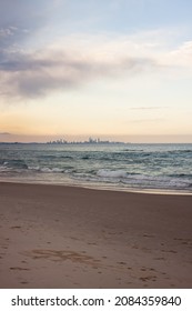 The city skyline seen from the town of Coolangatta in Queensland, Australia. Someone has drawn a flower in the sand.