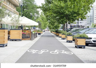 City Street With Long Bicycle Lane Near Outdoor Cafe