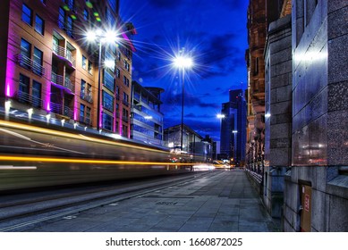 City street at night with a moving tram creating light trails. Taken in Manchester England.