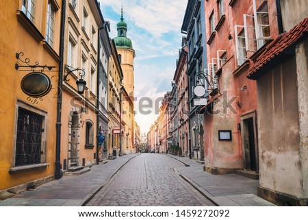 City street of old town in Warsaw. Narrow sunny street between colorful buildings of old town
