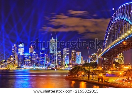 City of Sydney CBD waterfront landmarks and the Sydney Harbour bridge illuminated at Vivid Sydney light show 2022.