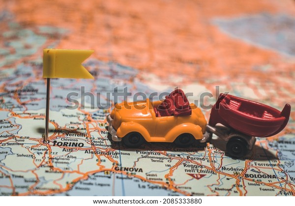 City\
of Torino, Italy pinned on map of Europe with yellow flag with car\
and boat next to it illustrating road trip to camping area or other\
vacation travel adventures with friends or family.\

