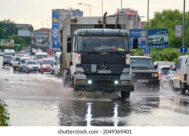 City traffic with cars driving on flooded street after heavy rain. Problems with road drainage system. Kyiv, Ukraine - June 24, 2021.