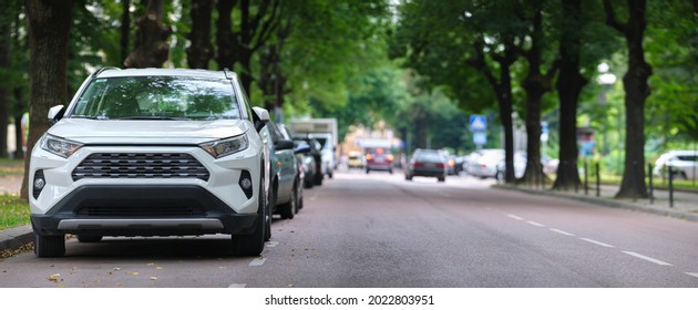 City traffic with cars parked in line on street side. Vehicle parking concept. - Powered by Shutterstock