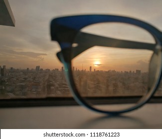 City View Focused On Glasses Lenses With Sunset.