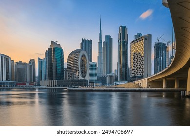 City view of the skyscrapers of Dubai City. Skyline of the Arabic city at sunset with the low sun. Business and financial buildings with Burj Khalifa in evening mood with bridge and road - Powered by Shutterstock