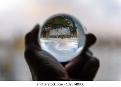 City View Through Crystal Ball Held In Hand By Male