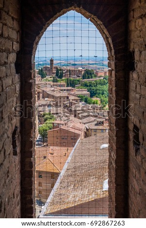 A city view through window in La Torre del Mangia, Piazza del Campo, Palazzo Pubblico. Siena, Italy.
