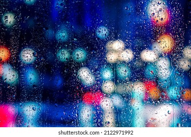 City view through a window on a rainy night,Rain drops on window with road light bokeh, City life in night in rainy season abstract background. Focus on drops on glass - Powered by Shutterstock