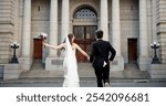 City, walking and back of couple for wedding at town hall for marriage certificate, ceremony and legal matrimony. Holding hands, love and man and woman at court for commitment, promise or partnership