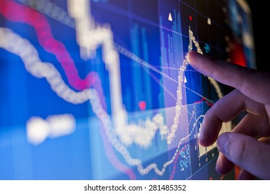 A City Worker Analysing Stock Market Data On A Monitor.