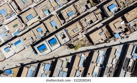 City of Xigaze at Tibet from the sky. Aerial view over a small Tibetan village in the mountain of the Himalayas. Drone view over the roof of Shigatse, Tibet, China. Small houses and narrow roads