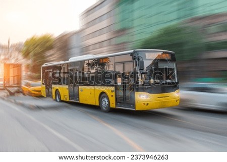 City yellow bus rush motion blur effect through the streets of the city in the evening at sunset peak hour