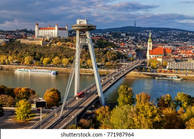 Cityscape of Bratislava with main symbols of the city: castle, SNP bridge over Danube river, St.MartinÂ´s church and broadcast tower in background. Warm sunset light.