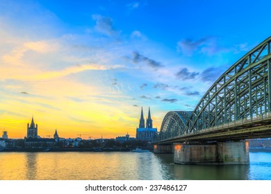 Cityscape Of Cologne From The Rhine River At Sunset