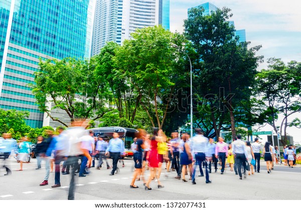 Cityscape with crowd of\
business people crossing road in Singapore downtown, metropolis\
skyline in background
