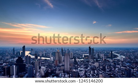 Cityscape in evening sunset from high angle view including modern architechture and Chaophraya River in Bangkok Thailand