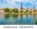 Cityscape of German town Ulm reflecting on river Danube.