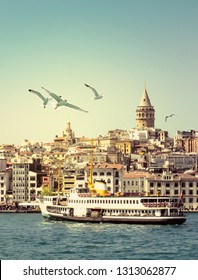 Cityscape of Istanbul with Galata Tower at skyline, steamboat and gulls over the sea. Seaside of Golden Horn at sunset as travel background for your vertical poster or billboard, vintage color tones.