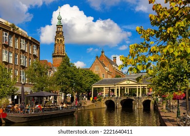 Cityscape of Leiden, South Holland, Netherlands. Embankment of city canal, view of bridge, town hall and Heilige Lodewijkkerk (St. Louis Church).