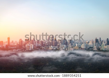 Cityscape of the office building with fog over the park in the sunrise at Bangkok, Thailand