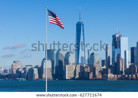Cityscape of the One World Trade Center in Manhattan Downtown, New York City with Hudson river and american flag in the front