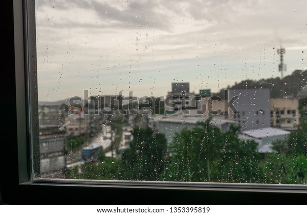 The cityscape outside the window flame after\
raining  on blurry\
background