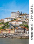 Cityscape of Porto (Oporto) over Douro River during a sunny day, Portugal. View of downtown Ribeira and embankment of Porto. Promenade view with colorful houses.