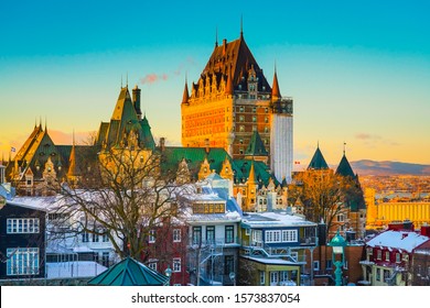 Cityscape view of Quebec City against St Lawrence river and colorful sky at dusk. Skyline scene of old port with snow covered buildings and ground in winter, Quebec, Canada. Building, Outdoor, Travel.