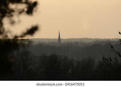 a cityskape with achurch during sunset in winter