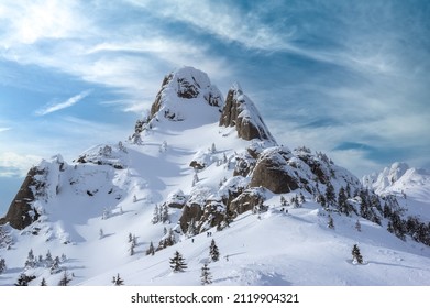 Ciucas mountains in winter, Romanian Carpathians. Fir trees and junipers full of frozen snow. There are hikers in the image. - Powered by Shutterstock