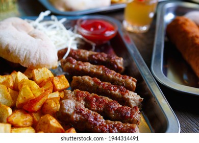 Civapcici Meat Kebabs And Baked Potatoes Served On Metal Tray For Dinner In Traditional Serbian Restaurant.Download Royalty Free Curated Images Collection With Foods For Design Template