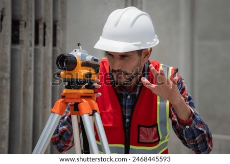 Civil or construction engineer using a survey camera, or an engineer with an auto level camera.
