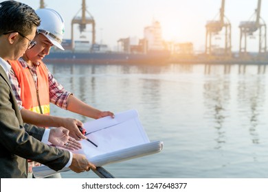 Civil Engineer Checking  Drawing With Walkie-talkie With Management Team At The Construction Site In Port