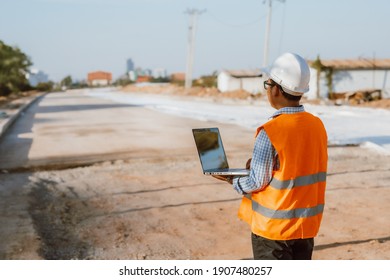 Civil Engineer At Construction Site Using Computer Laptop Checking Work. Management In The Construction Site.