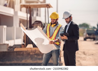 Civil Engineer And Construction Worker Manager Holding Digital Tablet And Blueprints , Talking And Planing About Construction Site.  Cooperation Teamwork Concept.