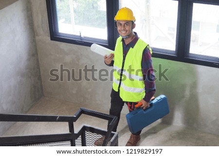 A civil engineer holds a toolbox and a work piece to prepare for work or repair or home inspection.    