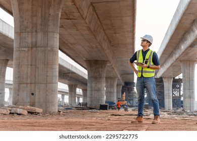 Un ingeniero civil está inspeccionando un proyecto de construcción de carreteras o autopistas en una carretera en construcción.