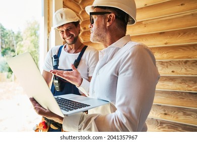 Civil engineer with laptop explaining something to housebuilder
