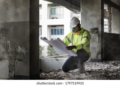 Civil Engineer People wearing face mask and safety helmet while looking to detail in drawing on construction site. Surveyor and checking in the Construction building for Demolishing and Renovate