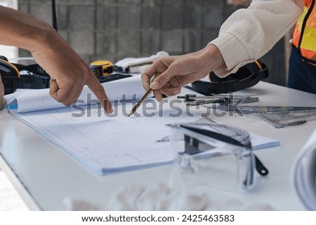 Civil engineer teams meeting working together wear worker helmets hardhat on construction site in modern city. Foreman industry project manager engineer teamwork. Asian industry professional team