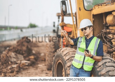 Civil engineer using tablet to record electronic data on construction site of concrete highway bridge