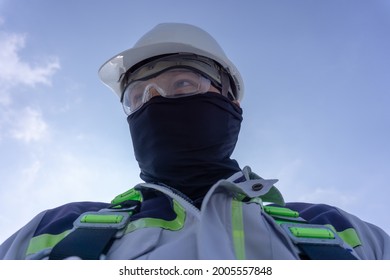 Civil Engineer Wearing Helmet And Safety Harness Working On Warehouse Roof Top