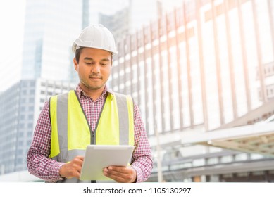 Civil engineering using tablet while working on building construction site.