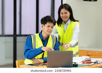 Civil engineers and architects discuss project construction together on laptop at the office and holding hard hat - Powered by Shutterstock