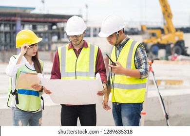 Civil engineers at construction site and a land surveyor using an altometer