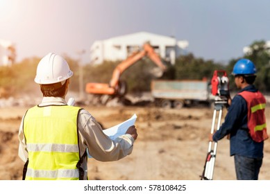 Civil Engineers At Construction Site And A Land Surveyor Using An Altometer