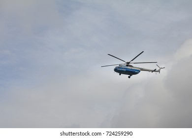 Civil helicopter in cloudy sky