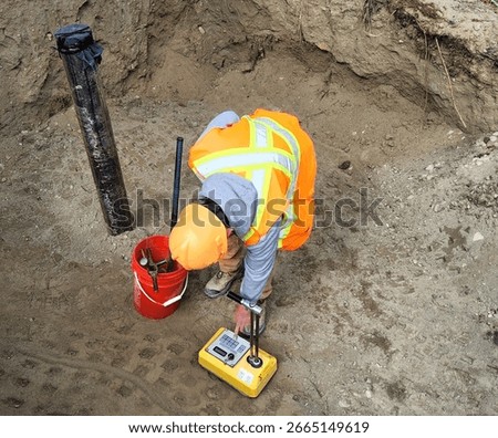Civil inspector performs nuclear densometer testing on compacted trench backfill to verify soil density meets project specifications.